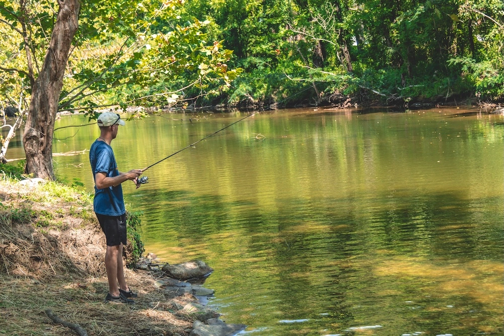 man fishing in riverslanding river